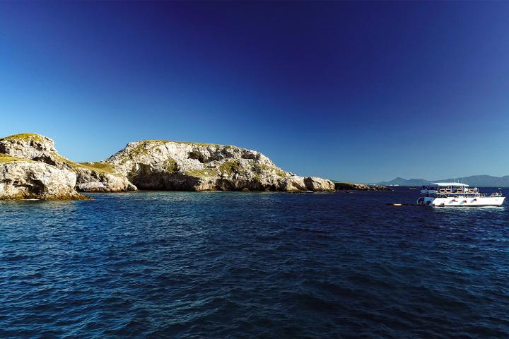 Islas marietas y barco de servicios turísticos aproximandose a la costa.