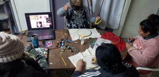 Mujeres en torno a taller de bordado en línea.